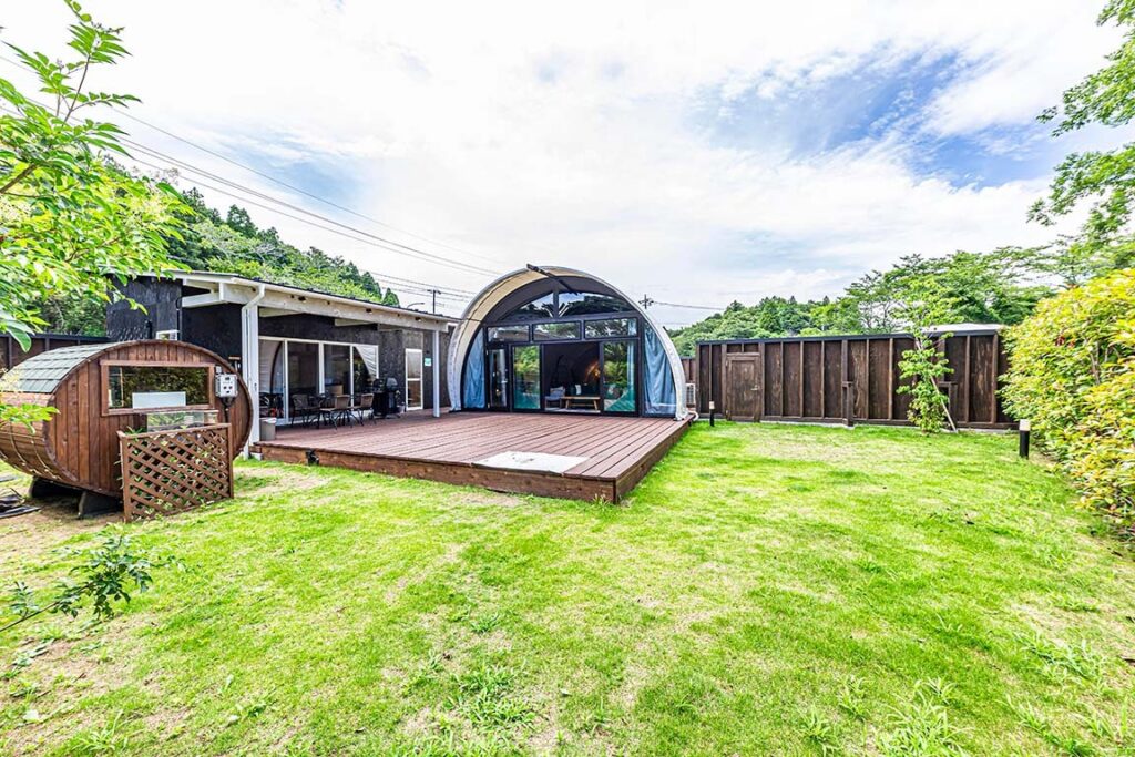 リトリートグランピング千葉亀山のコクーンテント棟と芝生の専用ガーデン、左手に屋外バレルサウナ